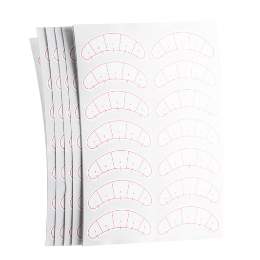 Stack of sheets displaying eyelash mapping stickers for lash techs.