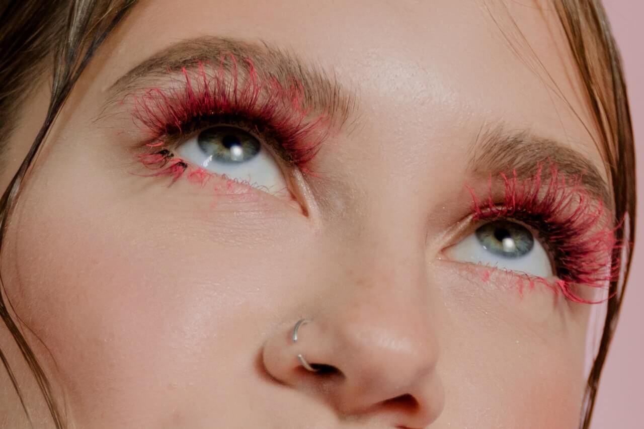 A woman with bright red colorful lash extensions