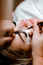 a blond woman receiving a lash extension treatment