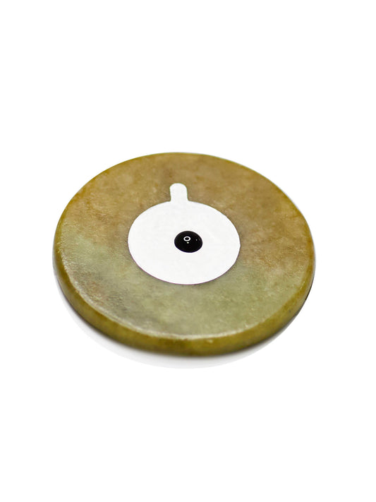closeup of eyelash extension glue drop on adhesive sticker on jade stone