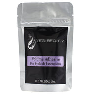 Silver pouch with black label. Purple rectangle with black lettering reads "Volume Adhesive For Eyelash Extensions"