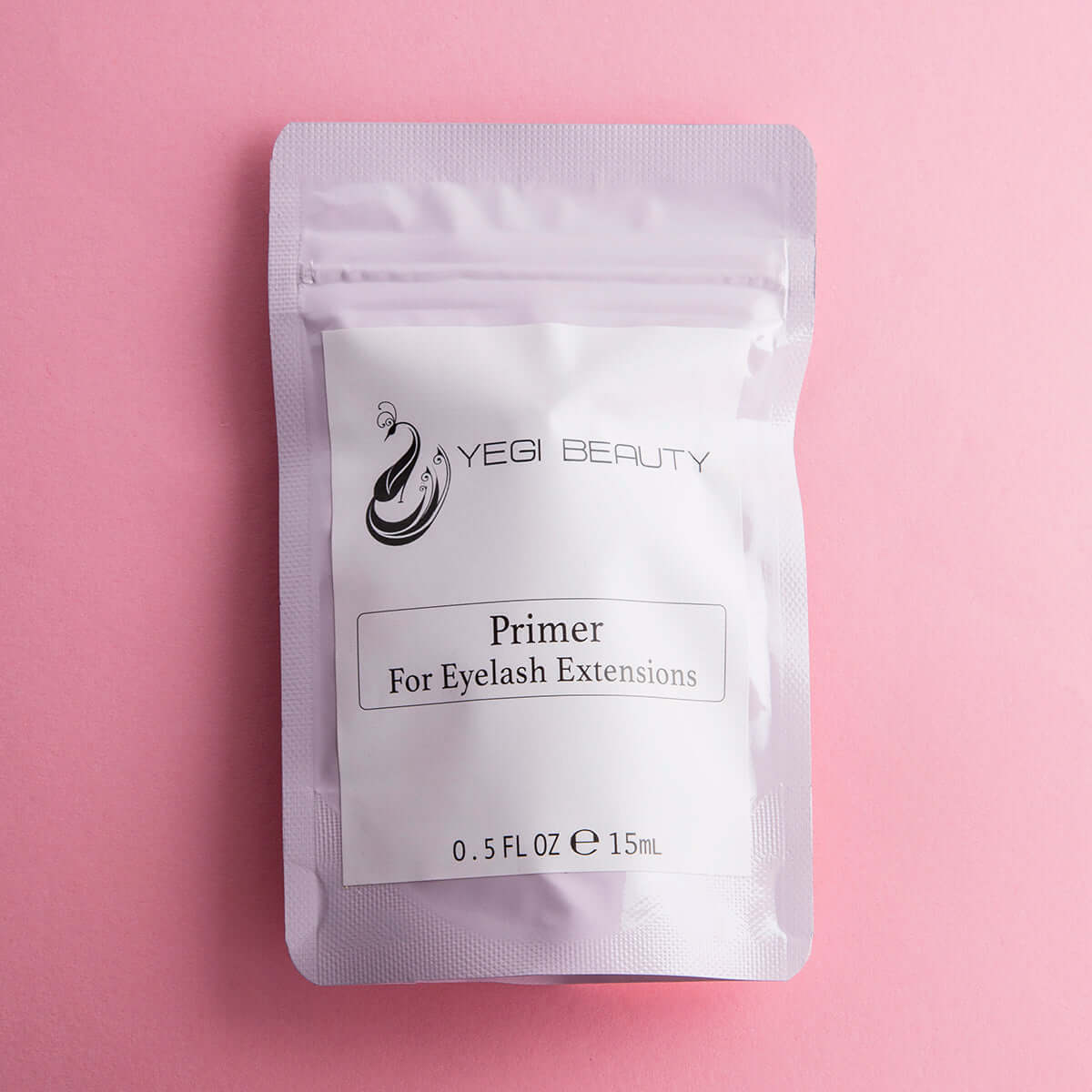 Light pink pouch against pink background. White label with black lettering reads "Yegi Beauty Primer For Eyelash Extensions"