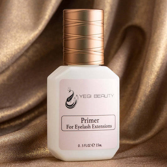15ml white bottle with gold cap and pink label. Label reads "Yegi Beauty Primer For Eyelash Extensions" in black letters. Product against golden fabric curtain like setting with round folds